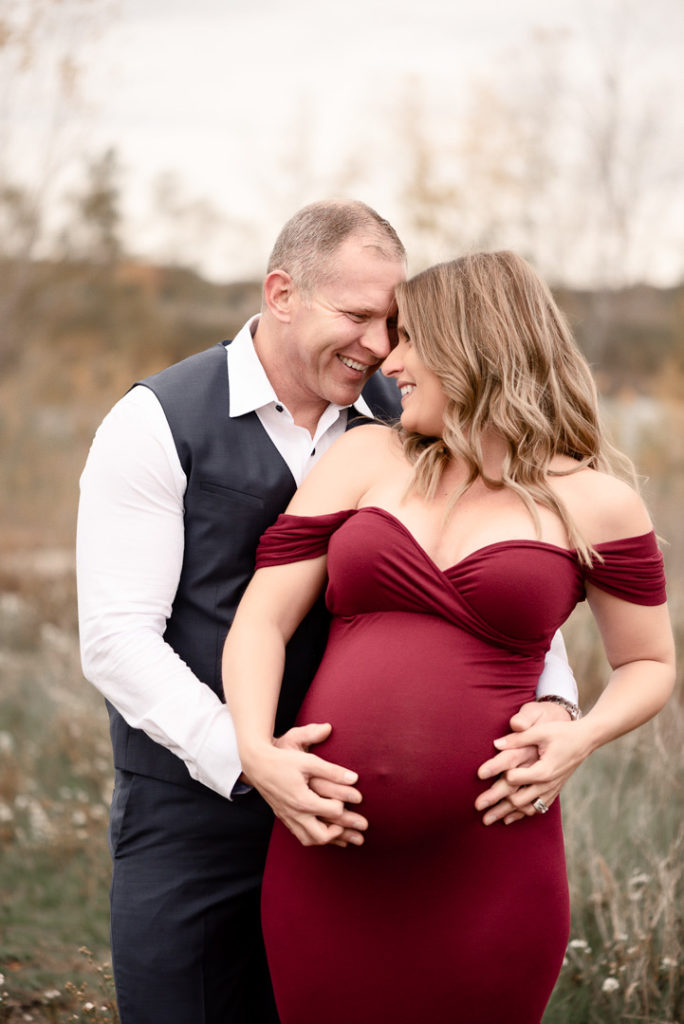 Lansing Maternity Photography Couple holding belly looking at each other