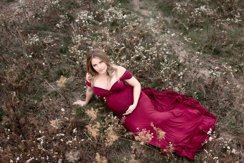 Maternity Photography Laying on ground holding belly.