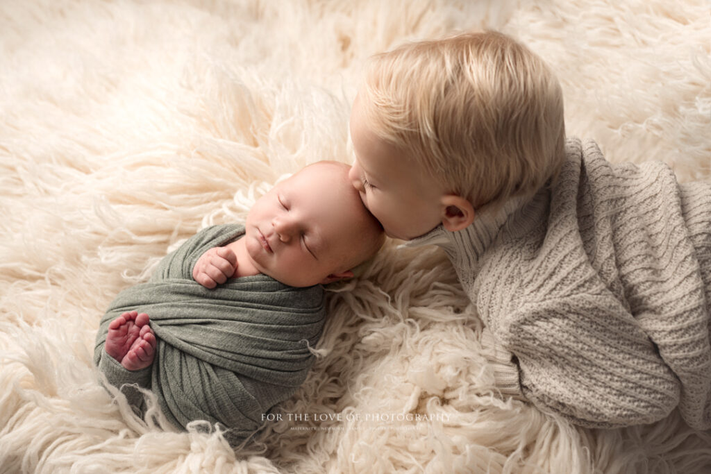 Professional Baby Photography Big brother kissing newborn by For The Love Of Photography